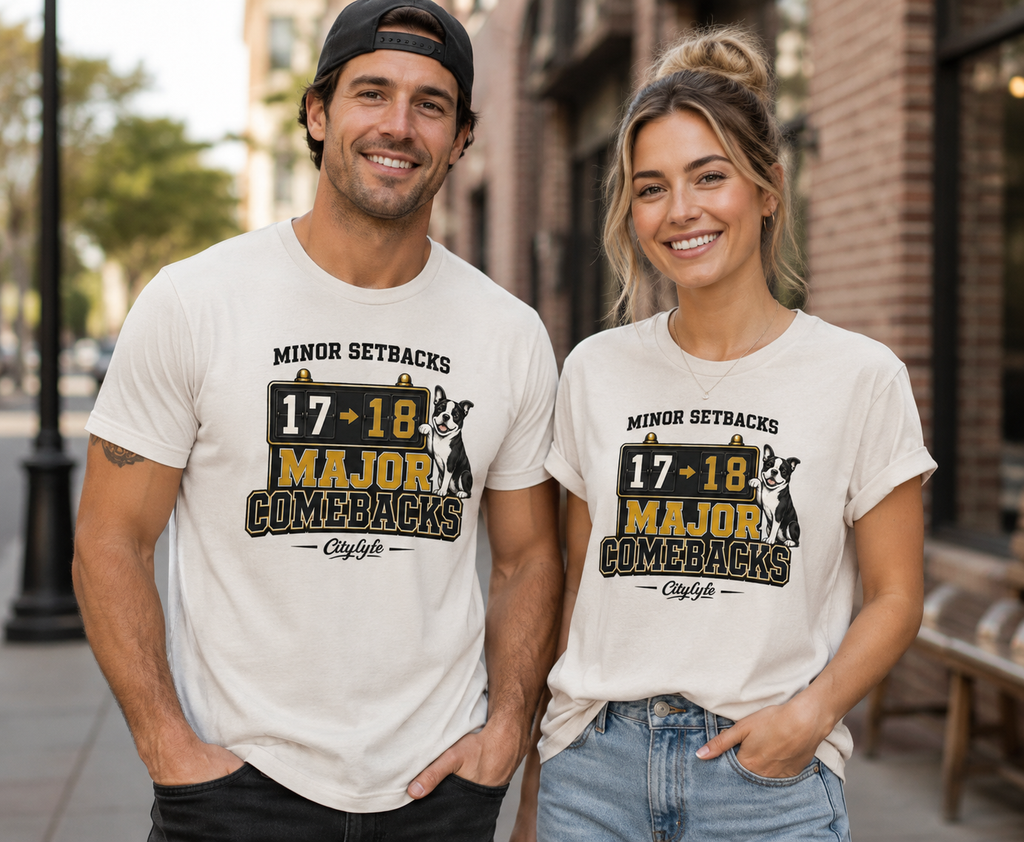 Man and woman wearing matching t-shirts with a graphic design on a city street.